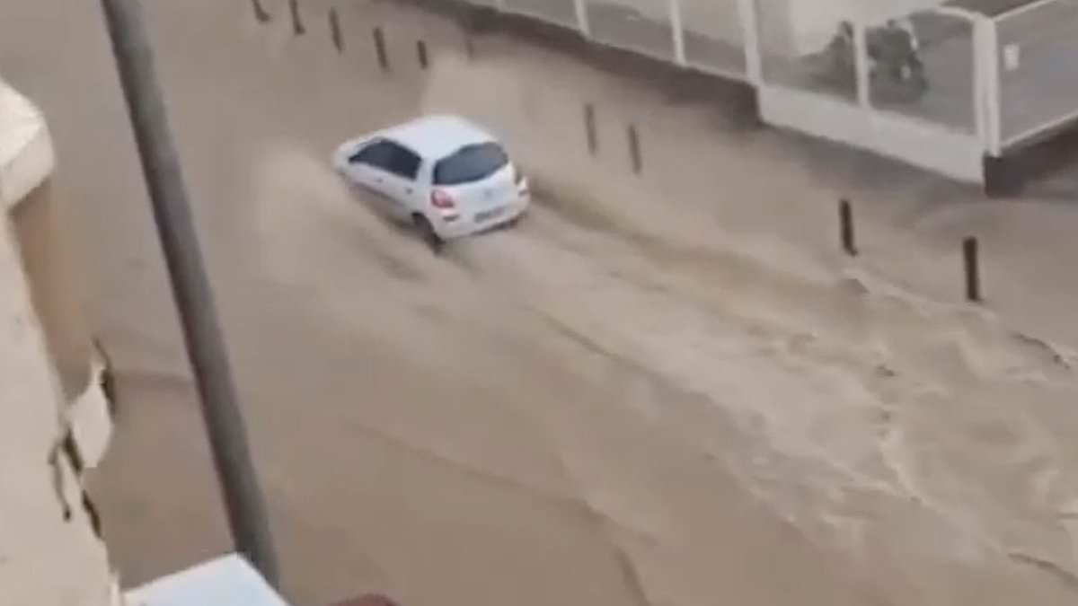 Rain in Spain! Flood and hail warning as holiday hotspot is deluged - while Britain basks in the sun